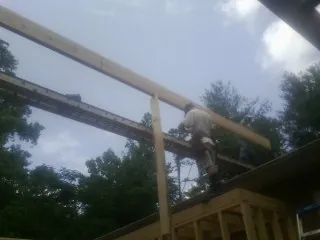 Carpenter setting a ridge beam over a new addition frame — Ice Dam Removal by Roofing Brothers in North Wales