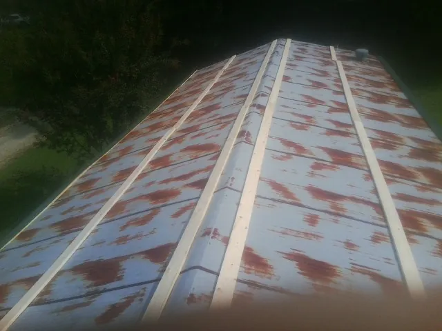 Rusted metal roof panels with new wood purlins before replacement — Storm Damage Roof Repair in North Wales by Roofing Brothers