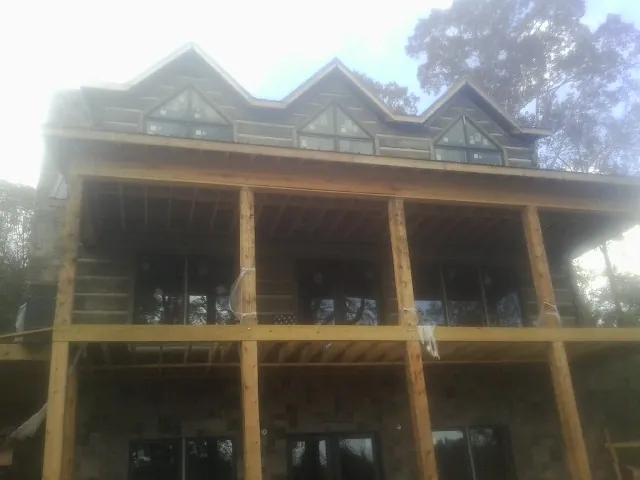 Dormers and porch framing on a large log home under construction — Roof Coating work by our crew in North Wales