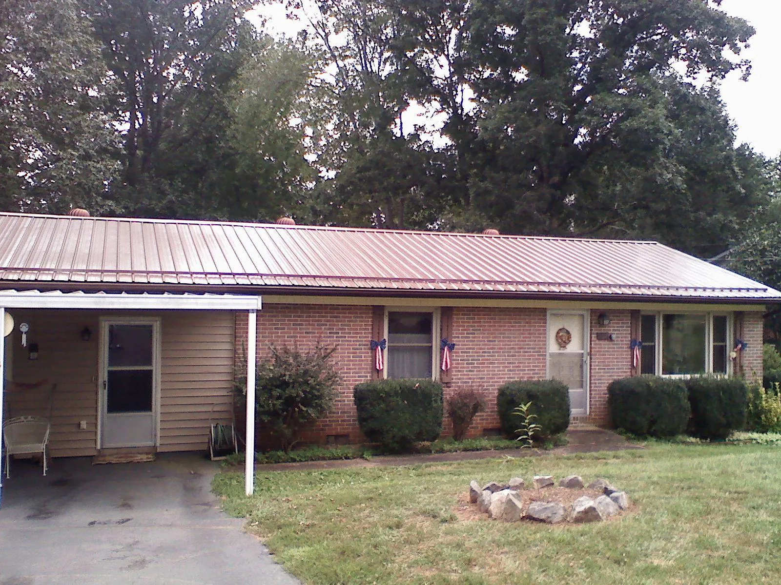 Bronze metal roof and carport on a brick ranch home — Roof Repair work by our crew in North Wales