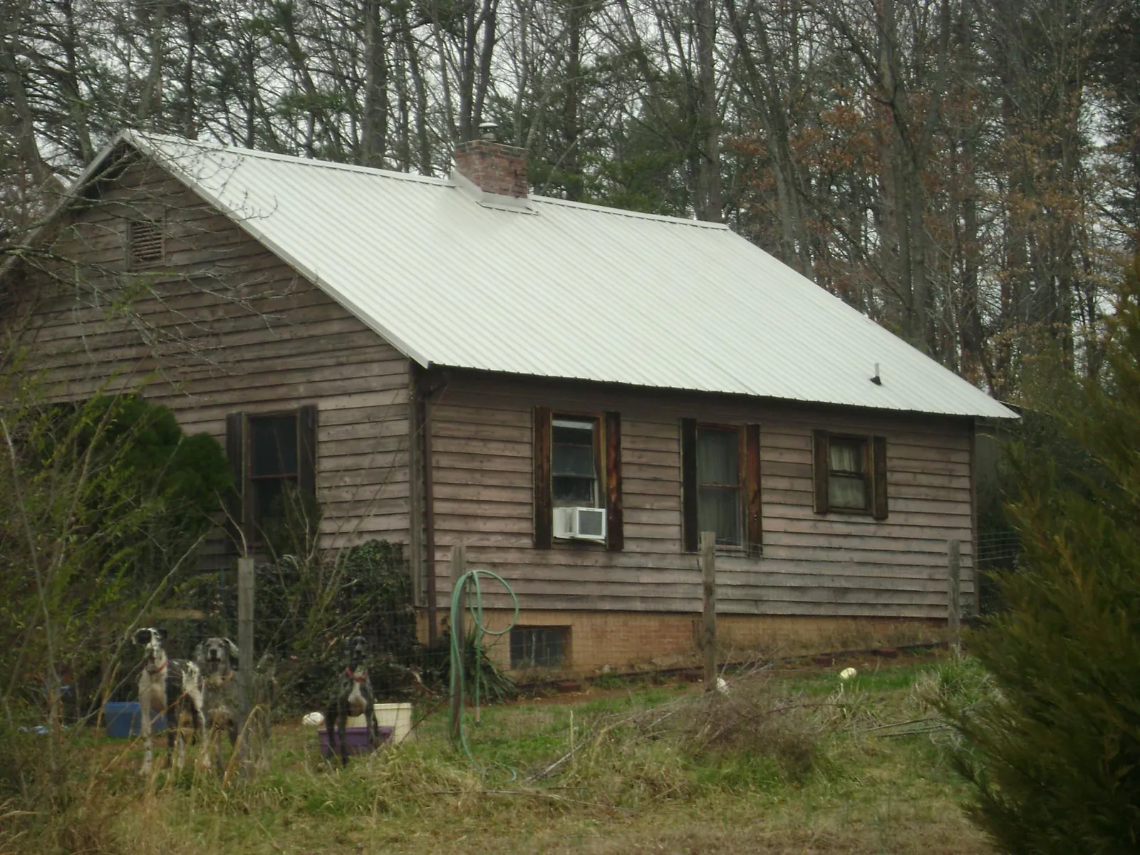 White metal roof on an old wood sided farmhouse, from a Metal Roof Installation job in North Wales
